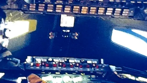 Benn family A grainy image of the inside of a Concorde cockpit, showing many of the plane's controls and dials.