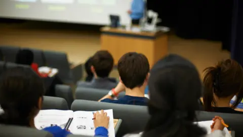 Students reading book in class.