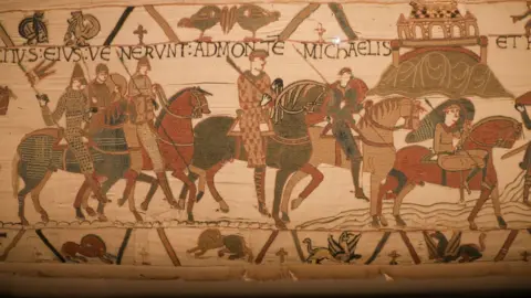 FILE PHOTO: A scene on the Bayeux Tapestry depicts horsemen and Mont Saint-Michel, believed to be one of the earliest known visual representations of the French landmark