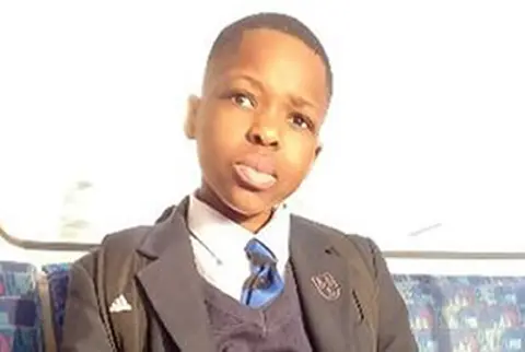 Daniel Anjorin pictured sitting on a bus wearing school uniform