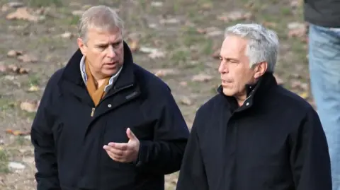 Andrew Mountbatten-Windsor and Jeffrey Epstein both dressed in coats talking in a park