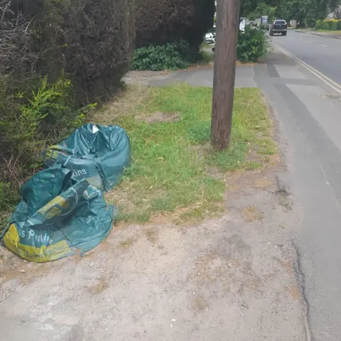 Frank Brown Two bags of sand left on the grass verge outside a property in Chilwell