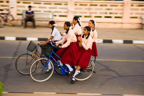 Getty Images Schoolmeisjes fietsen. Pondicherry, Tamil Nadu, India.