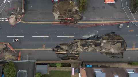 The scene in Godstone after a sinkhole appeared in the small village on Monday night. Surrey County Council has declared a major incident and local residents have been urged to avoid the area while repair work is being carried out. 