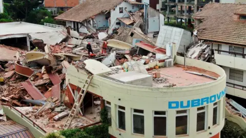 Reuters / Pablo Funes A drone image of the debris at the Dubrovnik hotel, which shows widespread damage to surrounding buildings and a lot of rubble. Rescue workers can be seen stood among debris.