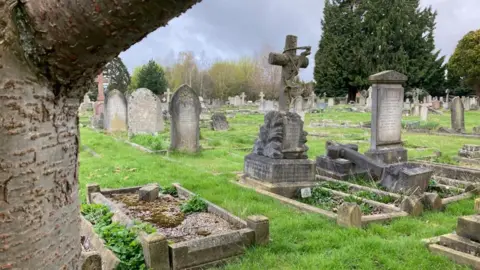 A graveyard, showing lots of older-style headstones. 