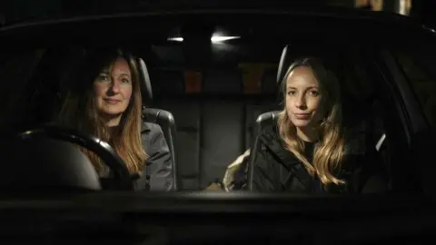 Rose Brown (left) and Jo Ritchie sat in a car looking direct to camera.