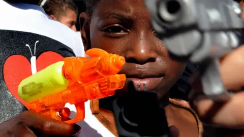 A boy plays with toy guns at a symbolic event in Medellín in 2009.