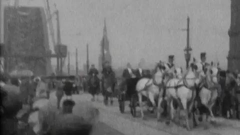 British Pathe A black and white image of King George V crossing the Tyne Bridge on 10 October 1928