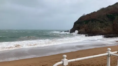 Richard Spalding/BBC A spotless sandy beach lashed by the waves of a winter storm. 