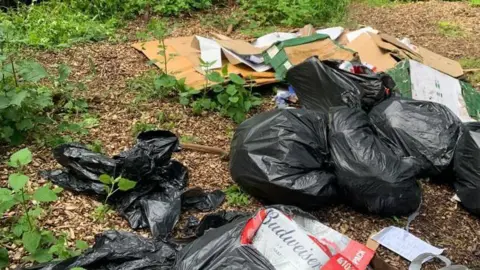 Black bin bags of rubbish lefts in a public path