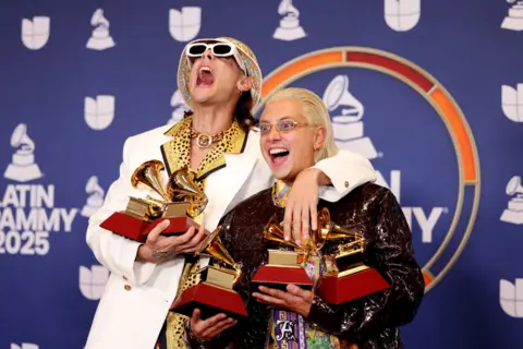 Reuters Ca7riel and Paco Amoroso celebrate while holding their five Latin Grammy trophies