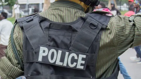 A Zambian police officer wears a flak jacket