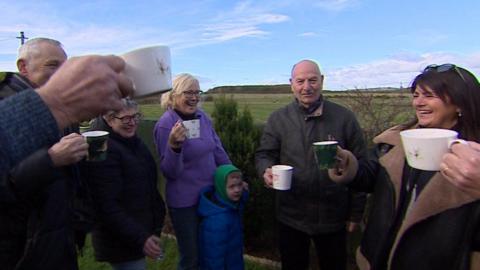 Group of campaigners toasting each other with mugs of hot drinks