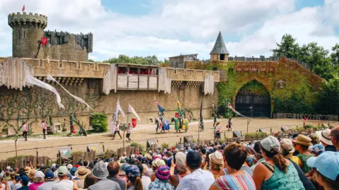 Puy du Fou A re-enactment at one of the Puy du Fou exhibits, with actors on horseback walking in front of a seated crowd 
