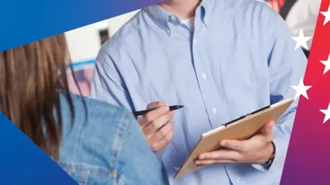 A man holding a clipboard and pen talks to a woman