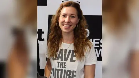 Amelia Twine Amelia Twine, who has long light brown hair and is wearing a t-shirt that says "save the future" on it.