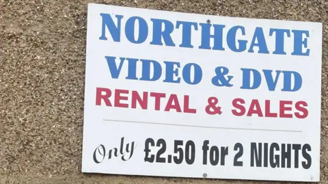 Rachael McMenemy/BBC Above a large window is a sign that reads 'Northgate Video and DVD rental and sales. Only £2.50 for two nights'. 