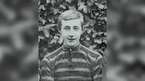 Cheltenham College A black and white photo of Fabian Woodley, who is wearing a striped top.