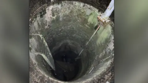 Dŵr Cymru Welsh Water Image of deep round tank with metal ladder visible on one side going down into the tank and a pipe on the other side.