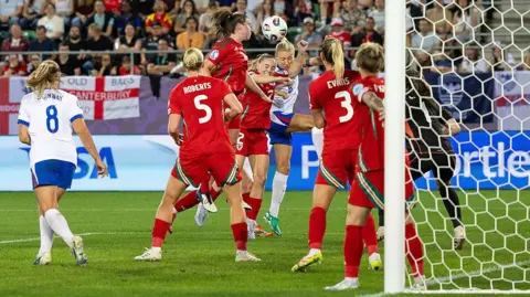 Getty Images Lily Woodham of Wales (L) fights for heading the ball with Leah Williamson of England (R) during the UEFA Women's EURO 2025 Group D match between England and Wales at Arena St. Gallen on July 13, 2025 in St Gallen, Switzerland.