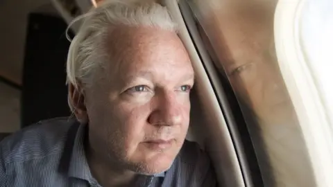 Wikileaks WikiLeaks founder Julian Assange looking out of the window of a plane while approaching Bangkok for a layover at Don Mueang International Airport, Thailand