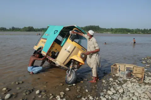 Fayaz Aziz / Reuters Men wash a rickshaw at the shore of Kabul river, 