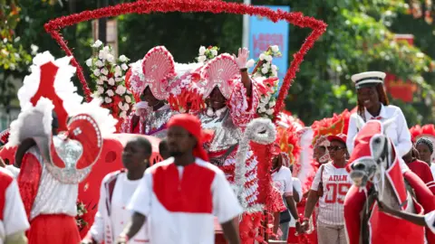 Reuters Individuals in red and white form a procession
