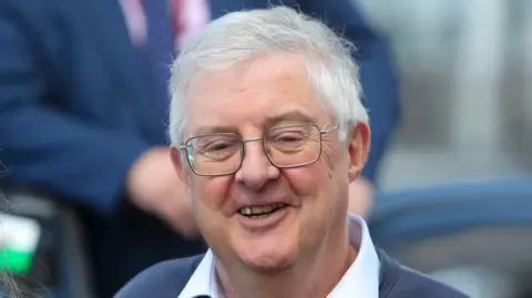 PA Media A head and shoulders picture of Mark Drakeford smiling.