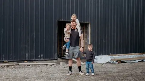 BBC Picture of Rhys Jones and his family outside his farm. 