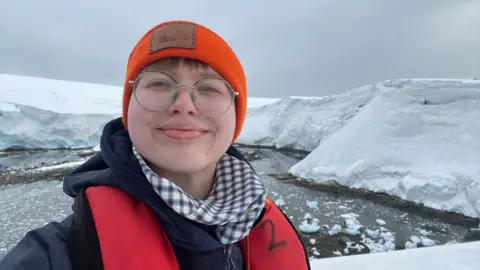 A woman standing outside in Port Lockroy, Antarctica 