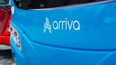 Arriva A close-up of the front of a blue bus. At the front there is the logo for bus operator Arriva.