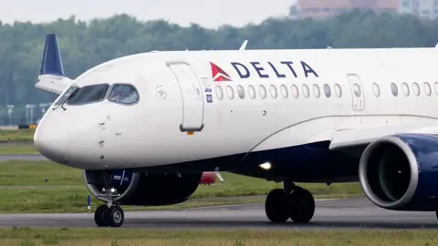 Getty Images A close-up photo showing a Delta Airlines plane landing on a tarmac in Arlington, Virginia.