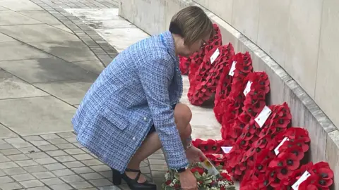 Beverley Franks laying a wreath at a war memorial service