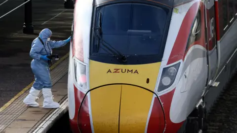 A forensic officer inspects the London North Eastern Railway (LNER) train where a series of stabbings took place, at a platform at Huntingdon Station. 