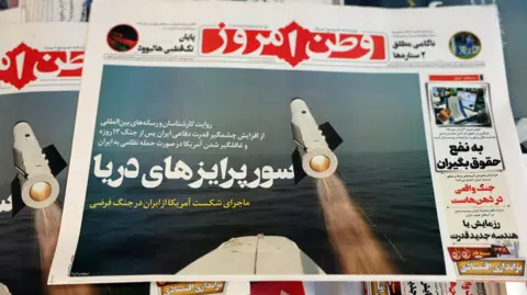 Copies of Iranian daily newspaper Vatan-e Emrooz, featuring a headline 'Sea surprises', are pictured outside a kiosk in Tehran