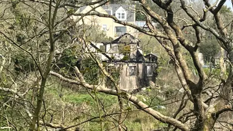 A shell of a building which was the scene of a large fire in Jersey. It has been badly damaged by the blaze. The roof of the building has gone and black char marks are on the exterior walls.