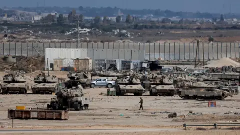 Reuters Israeli military personnel and tanks are stationed on the Israeli side of the Gaza perimeter, as seen from southern Israel (29 October 2025)
