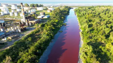 Getty Images This aerial view shows an unusual reddish colour of the Sarandí seeping into the Rio de la Plata on the outskirts of Buenos Aires