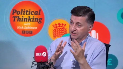 BBC Douglas Alexander sits in front of a BBC Radio 4 microphone and a backdrop reading "Political Thinking with Nick Robinson".