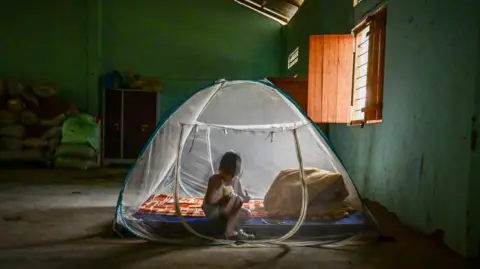 Getty Images A child from the Kuki ethnic group sits inside a tent at a relief camp for internally displaced people on April 27, 2024 in Litan village, Manipur, India. 