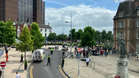 Police officers stand between two groups of people