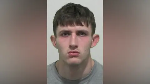 Northumbria Police Mugshot of Stokoe. He is clean shaven with short black hair.