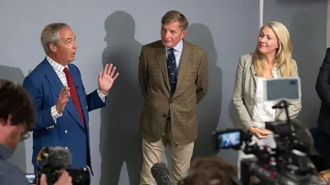 Getty Images Nigel Farage, David Jones and Laura Anne Jones at a press conference