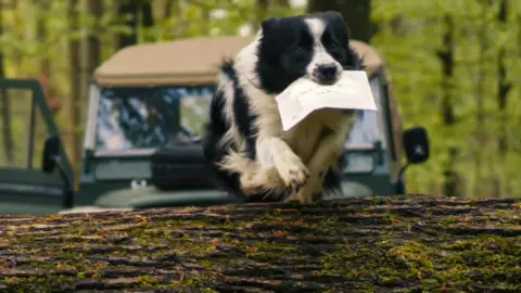 BBC Studios A dog delivering King Charles's letter to Sir David Attenborough