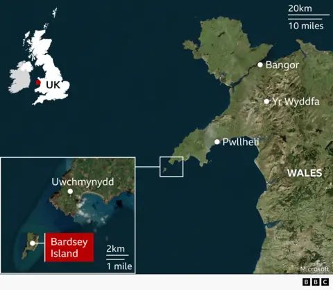 Satellite map of north‑west Wales showing the location of Bardsey Island off the Llŷn Peninsula. The mainland is labelled with key places including Bangor to the north, Yr Wyddfa (Snowdon) inland, and Pwllheli on the coast. A zoomed‑in inset in the bottom left shows Bardsey Island just off the western tip of the peninsula near the village of Uwchmynydd.