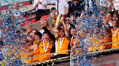 Hull City players lift a cup at Wembley as confetti is thrown 