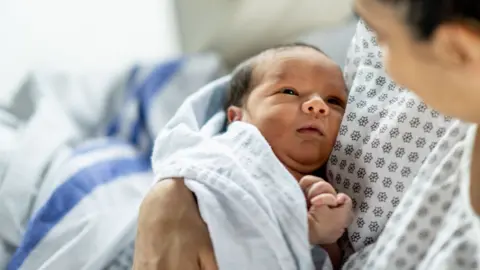 A newborn baby in a mother's arms 