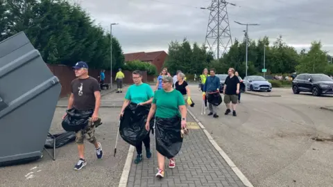 BBC/Alison Blackstone People carrying equipment to start clear up