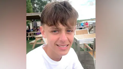 Supplied Billy Davies wearing a white t-shirt while sitting outside in what looks like a beer garden. He is smiling and looking at the camera.